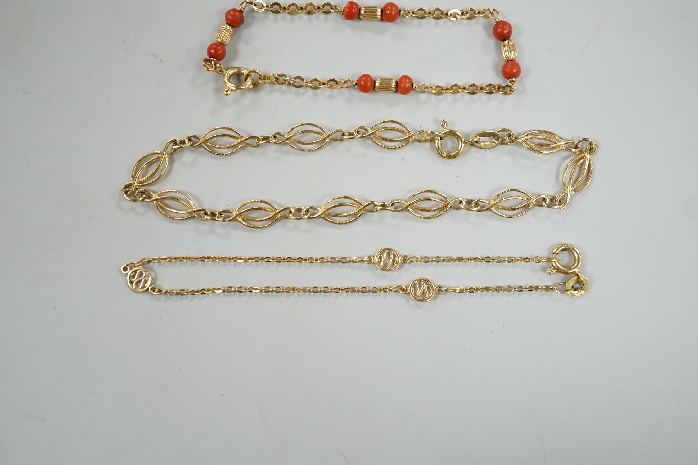 Four assorted 20th century 750 yellow metal bracelets, including child's with coral beads, 13cm